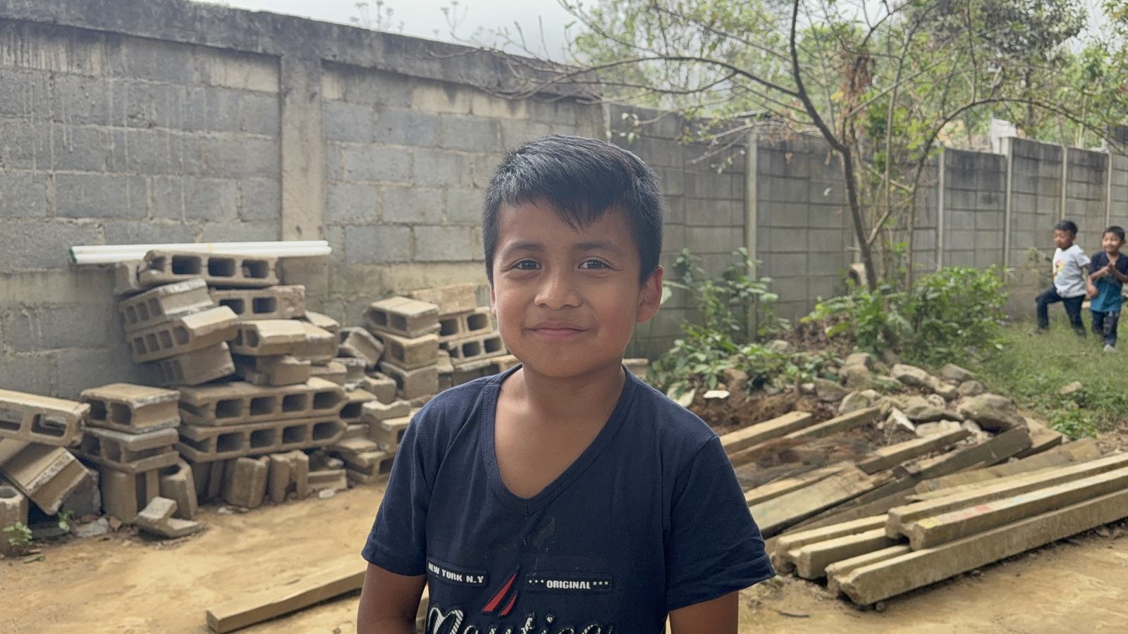 child in front of construction material aleluya